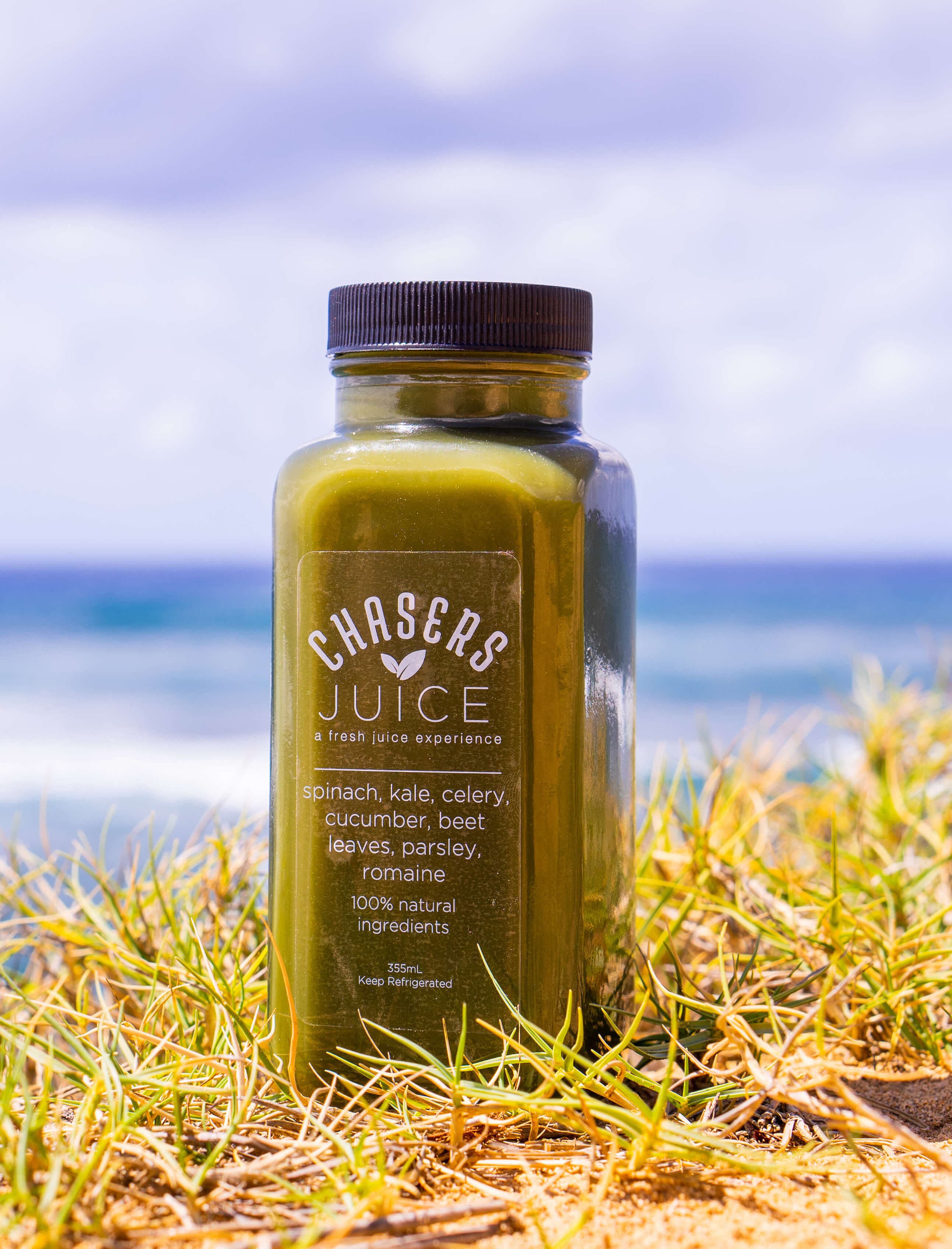 Spinach mix juice bottle with ocean in the background